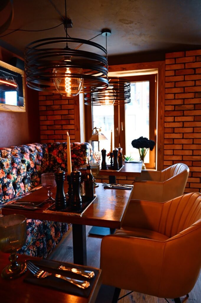 Sala restauracyjna z ceglaną ścianą i lampami